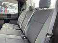 Interior view of the backseat of a 2017 Ford F-250 SD with gray fabric seats and seatbelts visible