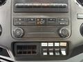 Dashboard controls of a 2016 Ford F-550 Super Duty featuring climate control knobs and various switches for auxiliary functions and radio