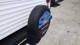 A black spare tire cover with the logo SMP RV and contact information for a trailer service