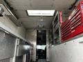 2006 GMC C5000 interior with metal cabinets and a red tool chest along the side