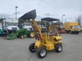 A yellow 2024 AGT KRW 23 mini loader with a front bucket and a cabin for one operator, featuring four wheels and a compact design