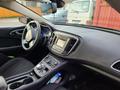 Interior view of a 2016 Chrysler 200 showing the dashboard steering wheel and center console with various controls and a display screen