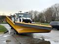 A 2016 Freightliner 108SD truck equipped with a large yellow snow plow attached to the front