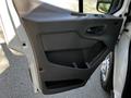 Close-up of the interior door panel of a 2021 Ford Transit featuring a handle and storage compartment