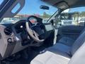 Interior of a 2015 Ford F-450 SD featuring a steering wheel dashboard and cloth seat with a focus on the driver's side