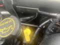 A close-up view of the engine compartment of a 2004 Ford Econoline showing various hoses and fluid caps, including a yellow cap labeled for transmission fluid and an oil cap