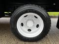 Close-up of a white wheel on a 2013 Ford F-650 featuring a large tire with deep treads and a multi-bolt pattern on the rim