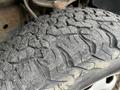 Close-up of a worn tire on a 2010 Ford F-150 showcasing a rugged tread pattern