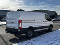 A 2018 Ford Transit van with a white exterior and black accents parked on a snow-covered street