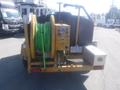 A yellow 2006 O'Brien 3515-CF trailer jetter featuring a green hose reel and control panel mounted on the back with a silver toolbox attached to the side