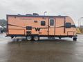 2015 Winnebago Of Indiana Travel Trailer with a distinctive orange exterior featuring black stripes and a prominent window design