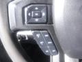 Close-up of the steering wheel controls of a 2018 Ford F-350 SD showing buttons for settings and cruise control options