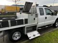 A 2014 Ford F-250 SD with a metal service bed featuring tool compartments and a spare tire mounted on the side