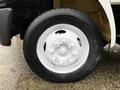 A close-up of a white wheel on a 2006 Hino 155 truck with a black tire featuring the tread pattern and brand markings clearly visible