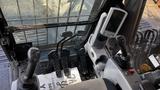 Interior view of a Caterpillar 326F L Excavator controls showcasing joysticks pedals and display panel