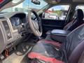 Interior of a 2012 RAM 2500 showing front seats with black and red leather upholstery steering wheel and dashboard with instrument cluster