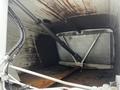 Interior of a 2014 Hino 195 truck showing a metal compartment with a hydraulic arm and wooden base and dirty surfaces