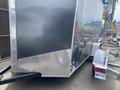 A 2020 Stealth Enterprises Trailer with a metallic gray exterior and diamond plate accents attached to a white trailer tongue