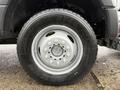 Close-up of a 2021 Ford F600 wheel showing a silver rim with multiple lug nut holes and a thick black tire with tread patterns