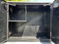 An empty black storage compartment with metal shelf brackets visible inside
