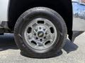 A close-up of a chrome wheel and tire from a 2016 Chevrolet Silverado 2500HD featuring a distinctive Chevy logo on the hubcap and rugged tread on the Goodyear Wrangler tire