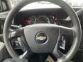 A close-up of the steering wheel of a 2016 Chevrolet Express showing the logo and various control buttons with the dashboard and gauges in the background