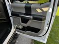 The image shows the interior door panel of a 2021 Ford F-550 featuring a gray and black design with a handle and storage compartment
