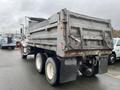 A 2003 International 5600i dump truck with a gray body and large tires viewed from the rear showing the dump bed and vehicle details
