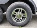 Close-up of a shiny chrome wheel with a circular design mounted on a black tire showcasing tread patterns and size markings