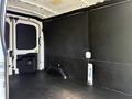 Interior view of a 2022 Ford Transit van showing a spacious cargo area with black paneling and a flat floor