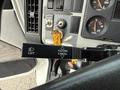 Close-up of a Freightliner FL80 control panel featuring a lift lever and hazard cancel switch with labeled buttons and a key in the ignition