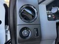 A control panel featuring an air vent a dial for headlights and a button for fog lights in a 2012 Ford F-350