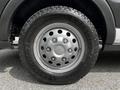 Silver wheel with five lug nuts mounted on a Goodyear Wrangler tire