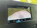 Screen display showing a rearview camera perspective for a 2023 Mercedes-Benz Sprinter with surrounding visuals of a driveway and bushes