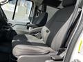 A 2018 Ford Transit interior showing two black fabric seats with armrests and a simple dashboard design