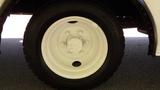 A close-up view of a white wheel and tire from a 2004 Freightliner MT45 showing the tire tread and wheel rim details