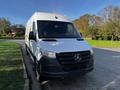 A 2022 Mercedes-Benz Sprinter van with a white exterior and black accents parked on the side of a road