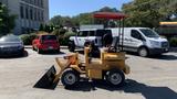 A yellow 2024 Traner TR45 small vehicle with a front loader attachment and a red canopy over the operator's seat