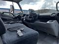 Interior of a 2019 Hino 195 featuring a driver's seat dashboard and controls with a seatbelt visible on the driver's seat