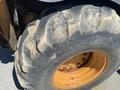 A close-up of a worn tire on a 2008 Case Super 580M loader showing a rugged tread pattern and orange wheel rim