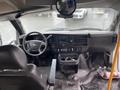 Interior view of a 2017 Chevrolet Express showing the dashboard steering wheel and driver seat with controls and console items visible