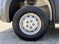 Close-up of a silver wheel with five lug nuts on a 2021 RAM Promaster tire showcasing the tread pattern and brand name on the rubber