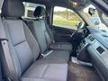 Interior view of a 2011 Chevrolet Avalanche showing two front seats with gray fabric upholstery and a dashboard with controls and a gear shift visible