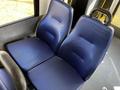 Two blue upholstered seats in a 2019 Chevrolet Express designed for passenger comfort