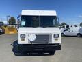 A white 2012 Ford Econoline with a flat front and large windshield featuring a metal plate mounted on the front grille