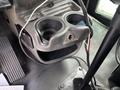 Interior view of a 2013 Kenworth T370 showcasing the cup holder and panel with a small opening and wiring visible