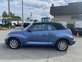 A blue 2007 Chrysler PT Cruiser convertible with a black soft top and chrome wheels viewed from the side