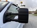 A close-up view of the side mirror of a white 2008 Ford F-450 truck