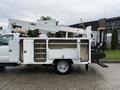 A 2008 Ford F-550 truck equipped with an Altec aerial lift and a utility body featuring multiple storage compartments on the side