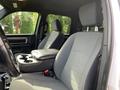 Interior of a 2021 RAM 1500 showing two front seats with fabric upholstery and a center console with cup holders